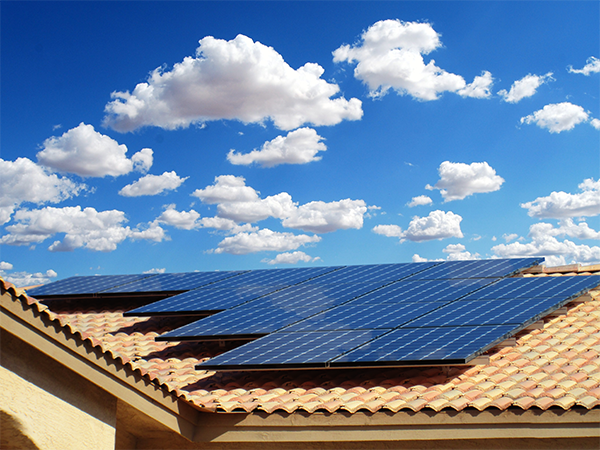 solar panels on roof with clouds in the background