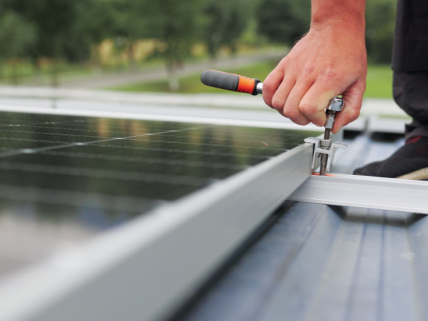Person tightening down a solar panel