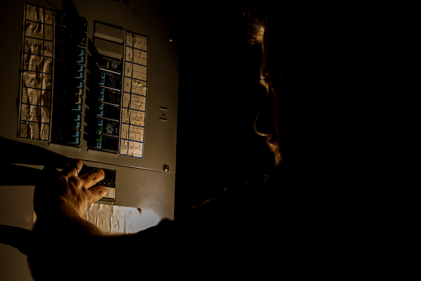 Man looking at electrical panel during power outage