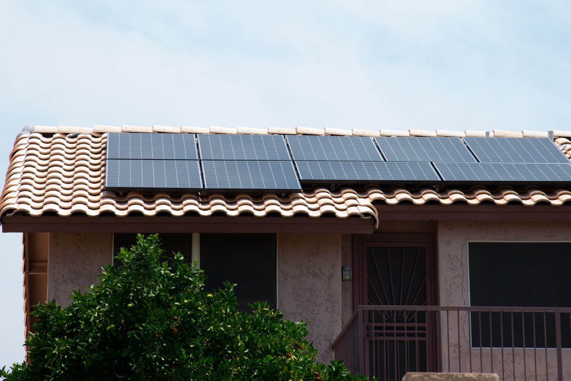 black solar panels on the roof of a stone house