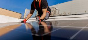 person placing solar panel on rooftop