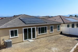 home with all black solar panels with dirt back yard