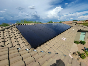 all black rooftop solar panels on a home in arizonia with a cloudy sky