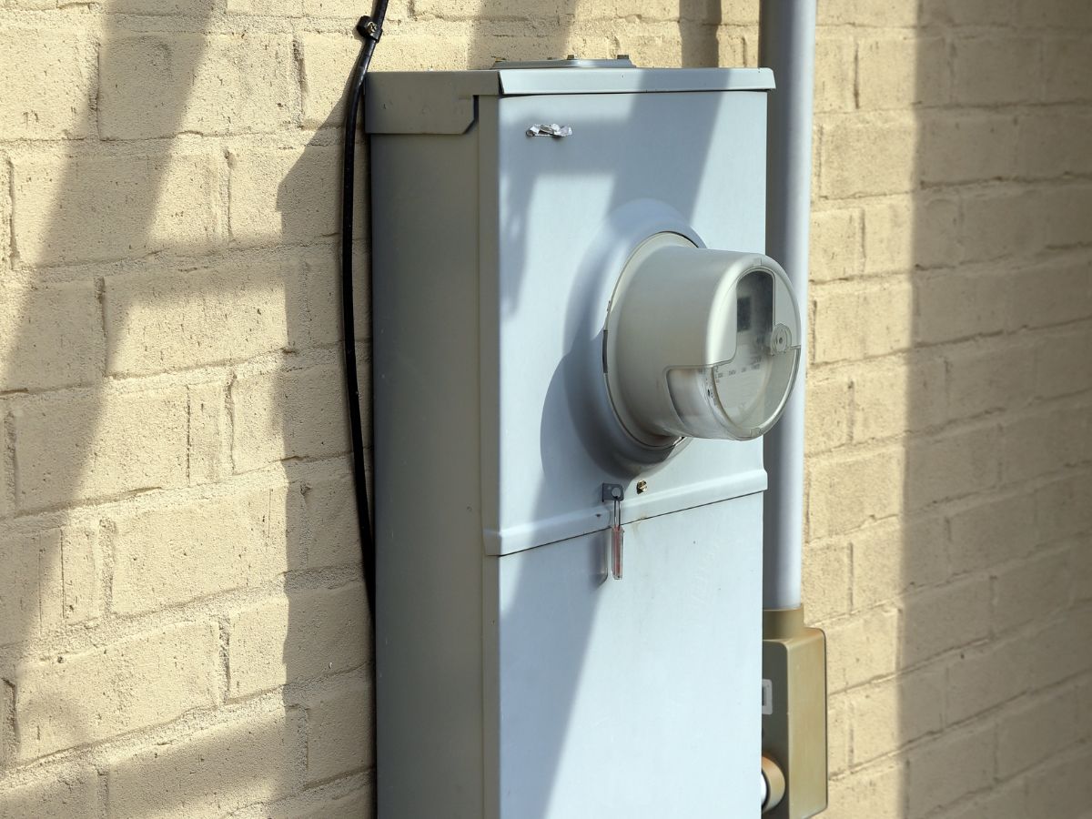 electrical meter on the side of a tan brick home